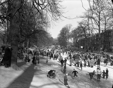 816454 Afbeelding van schaatsende mensen op de bevroren Stadsbuitengracht te Utrecht, met rechts de huizen aan de ...